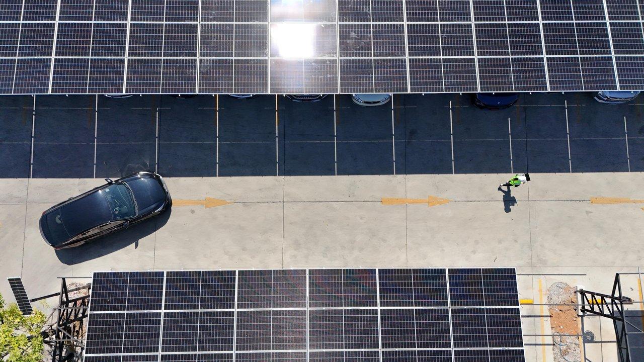 Véhicules électriques d’occasion stationnés près de panneaux solaires, symbole d'une mobilité responsable et durable.