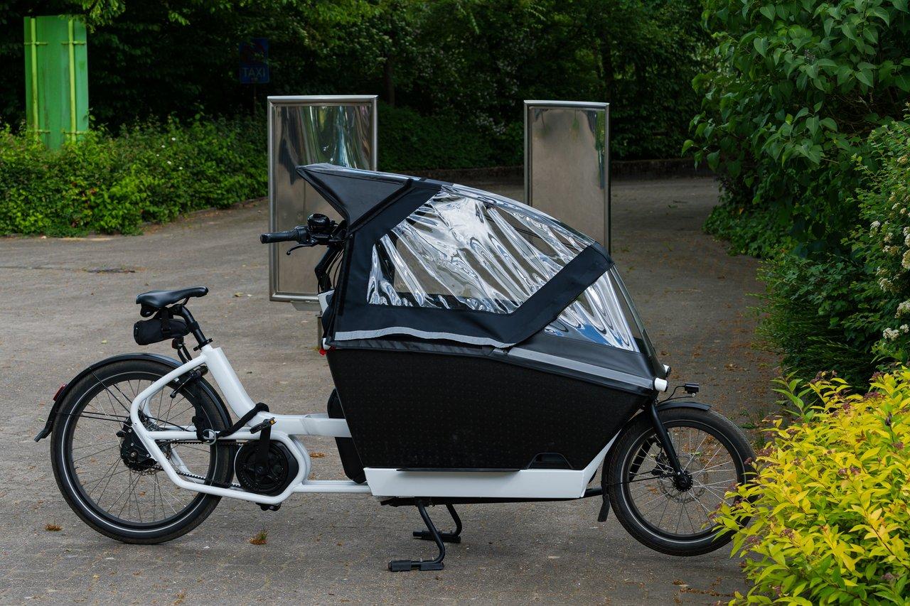 Vélo cargo triporteur électrique avec caisson de livraison, idéal pour le transport de colis en ville en 2026.