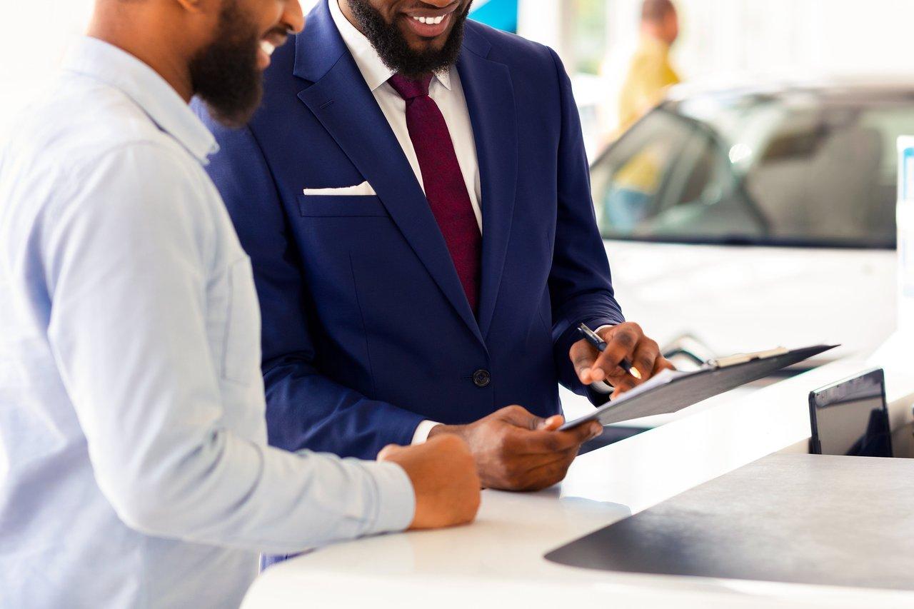 Vérification des documents administratifs lors de l’achat d’un véhicule d’occasion chez un professionnel.