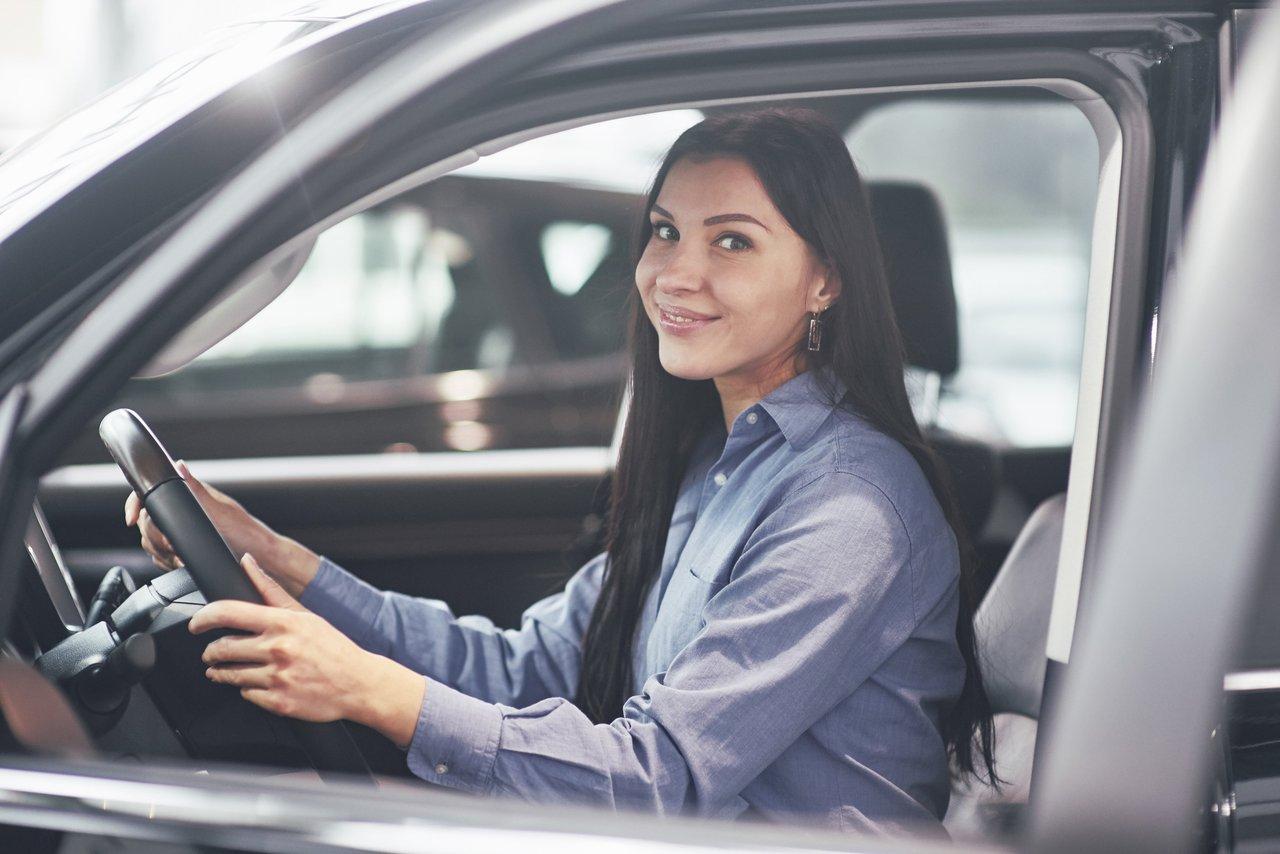 Visite enthousiaste au car auto show : une femme reçoit ses clés d’une nouvelle voiture.