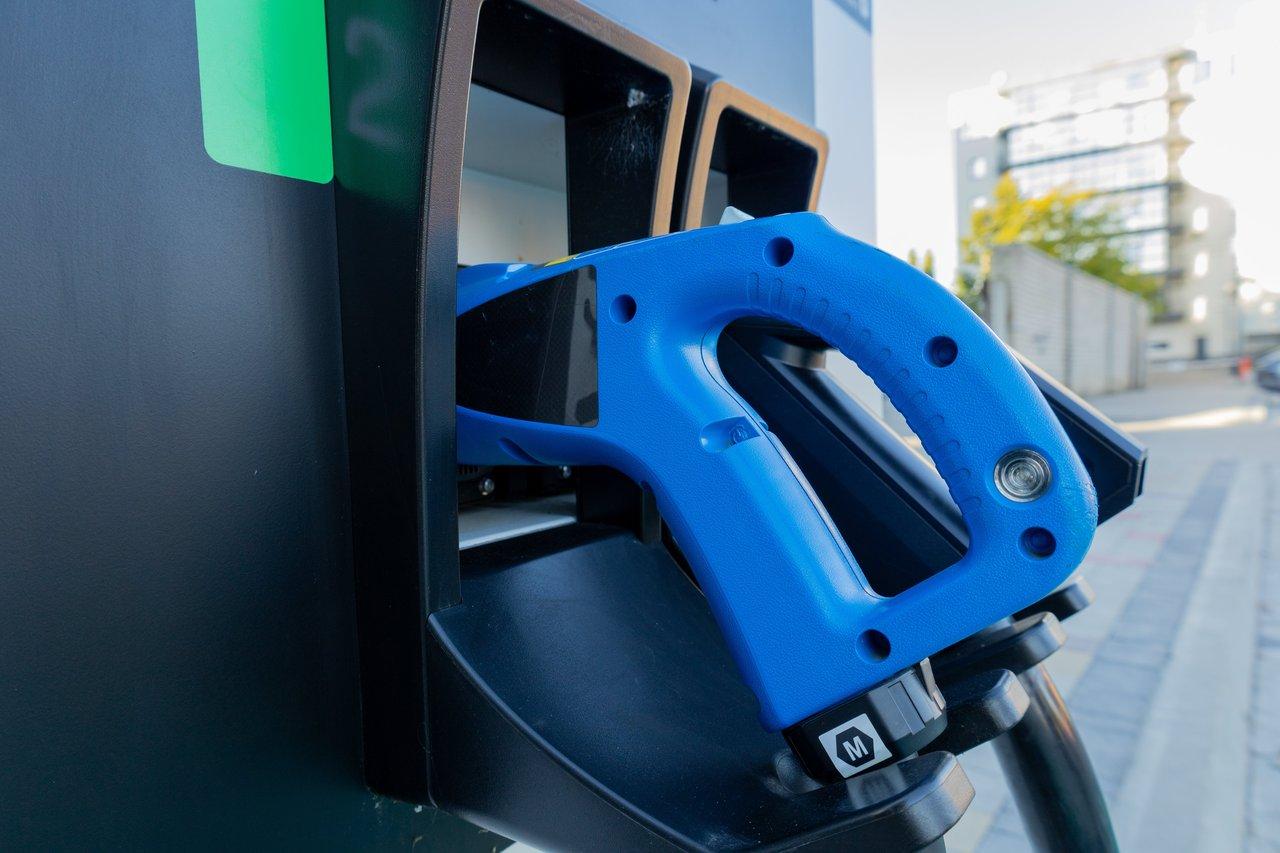 Voiture à hydrogène en pleine recharge dans une station moderne en milieu urbain, illustrant la technologie du futur.