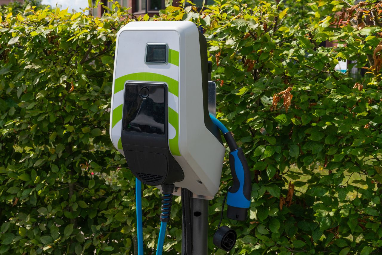 Voiture électrique en recharge sur borne rapide extérieure affichant clairement le prix au kWh, technologie moderne écologique