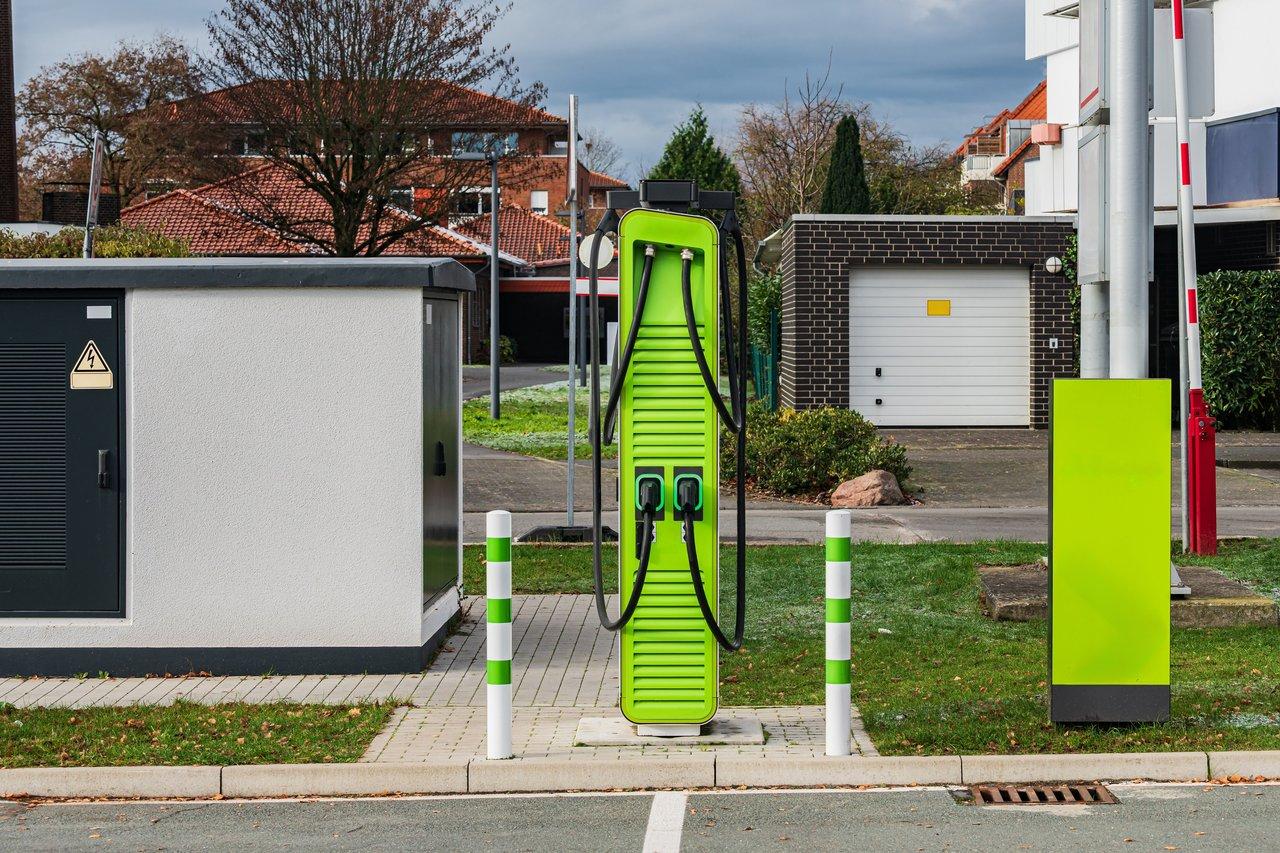 Voiture électrique stationnée à l’ombre en ville avec panneau solaire sur le toit, illustration de la gestion thermique en usage urbain intensif.