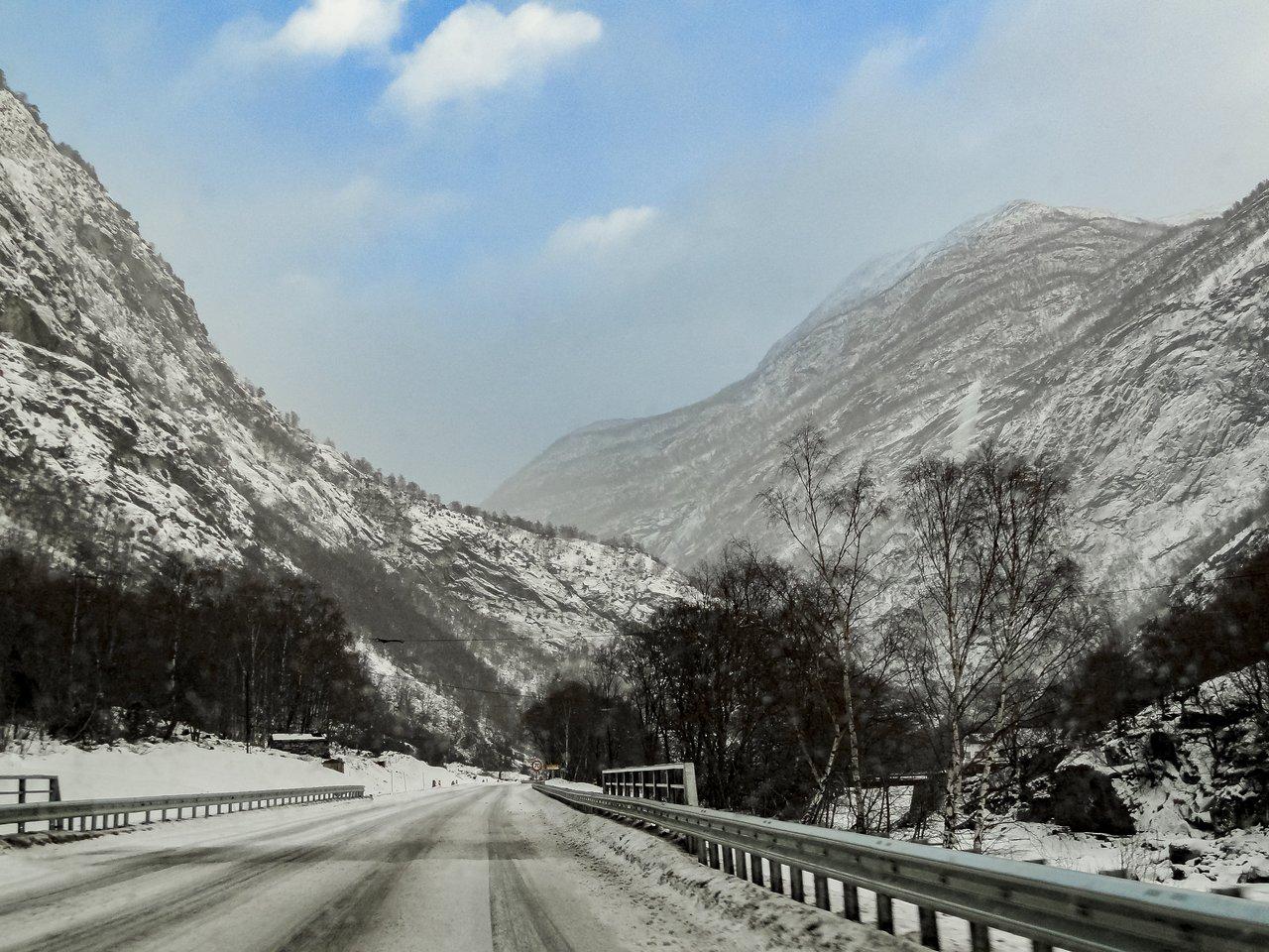 Voiture équipée de pneus hiver 3PMSF circulant en milieu montagnard enneigé, illustration de la conduite en conditions hivernales.