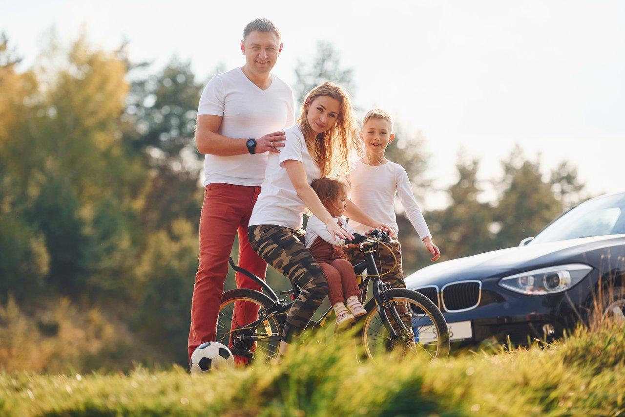 Voiture familiale équipée d’un coffre de toit et porte-vélos en automne pour une rentrée pratique.