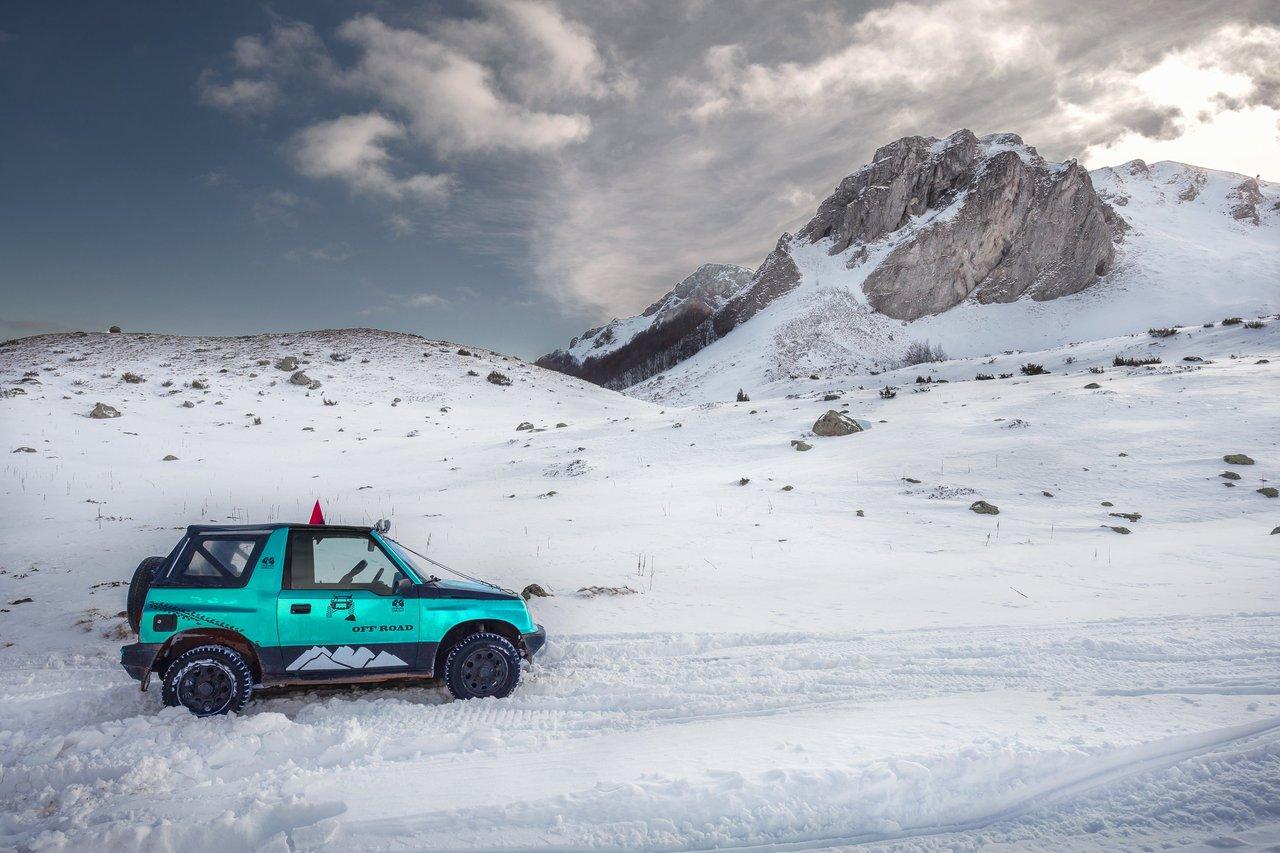 Vue de face d’un modern SUV équipé d’un système de traction intégrale sur une route montagneuse enneigée, garantissant sécurité et performance.