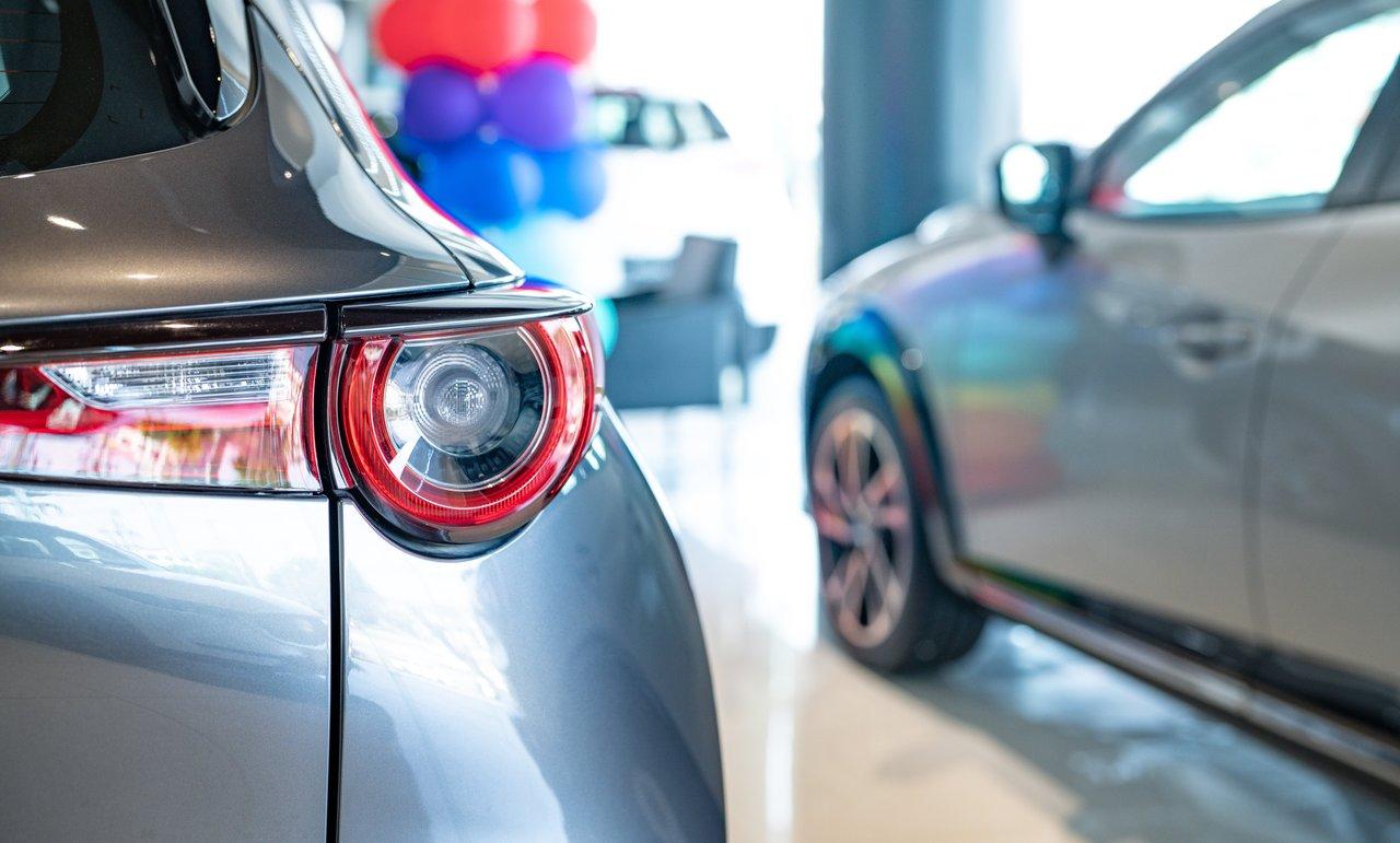 Vue du stand Tesla présentant une voiture électrique innovante avec interfaces technologiques avancées dans un showroom moderne.