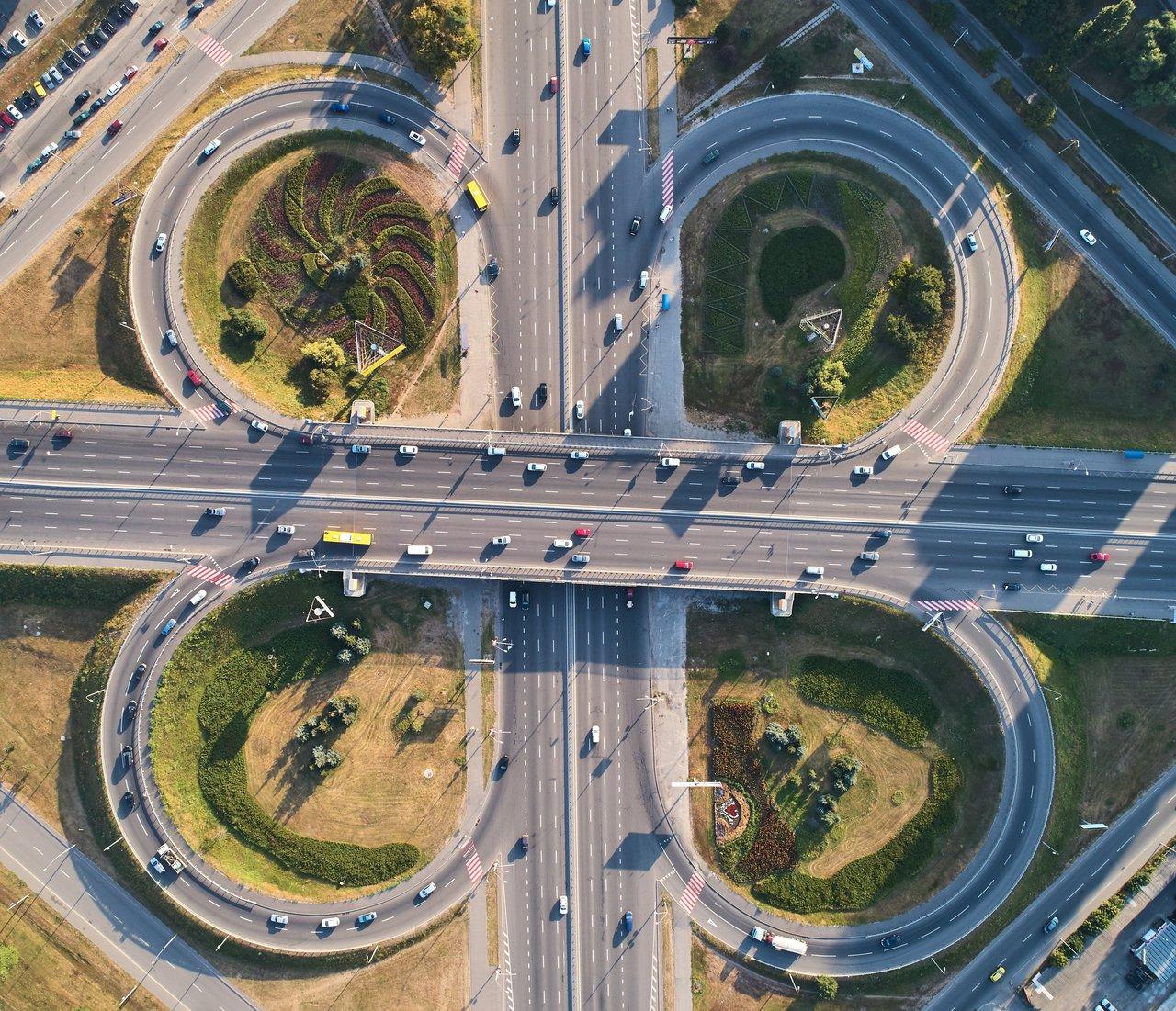 Vue panoramique d'une intersection de smart city équipée de capteurs, véhicules autonomes et feux connectés.