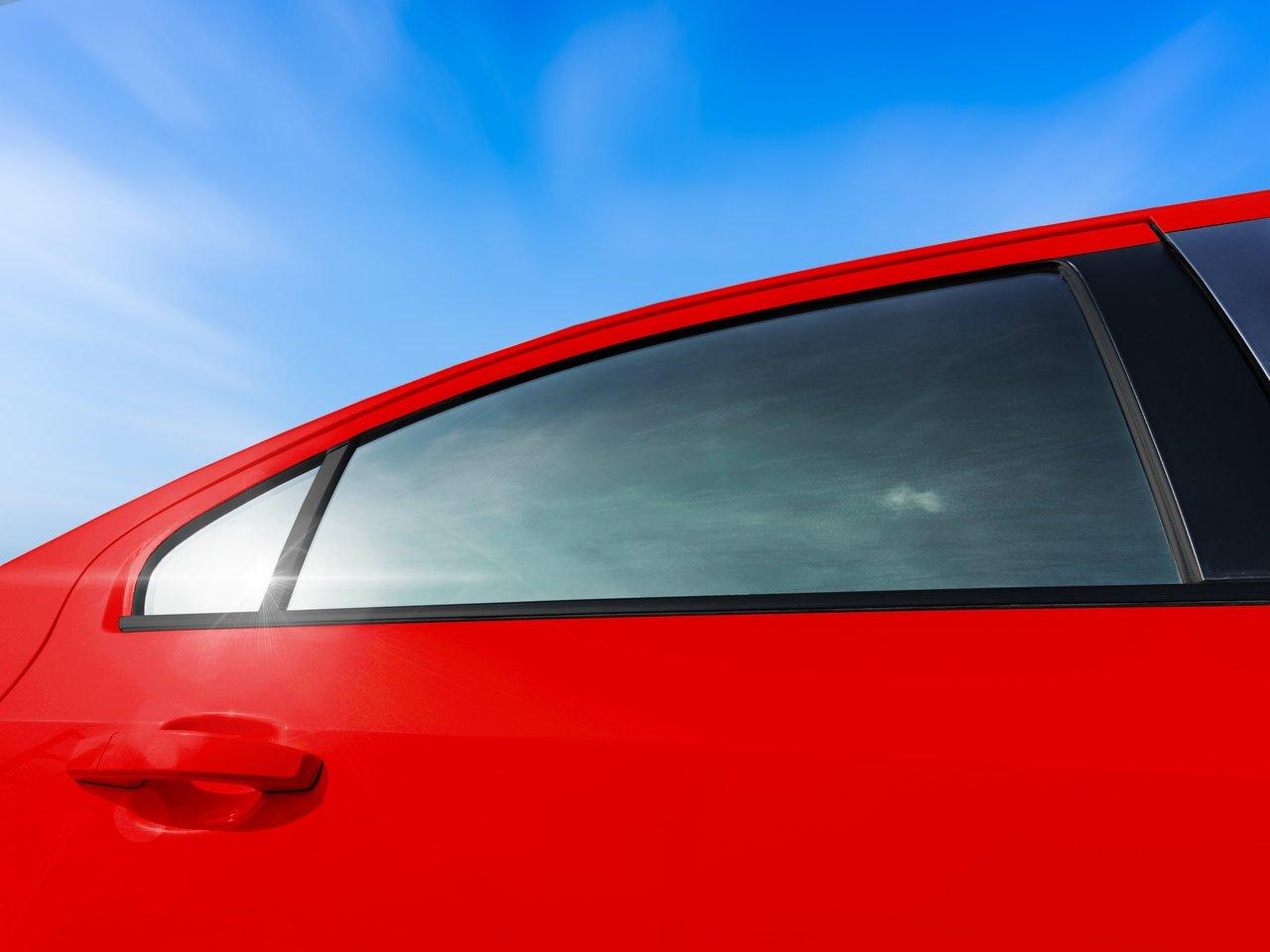 Vue rapprochée d’une vitre de voiture avec film solaire, réduisant l’éblouissement et renforçant l’intimité.