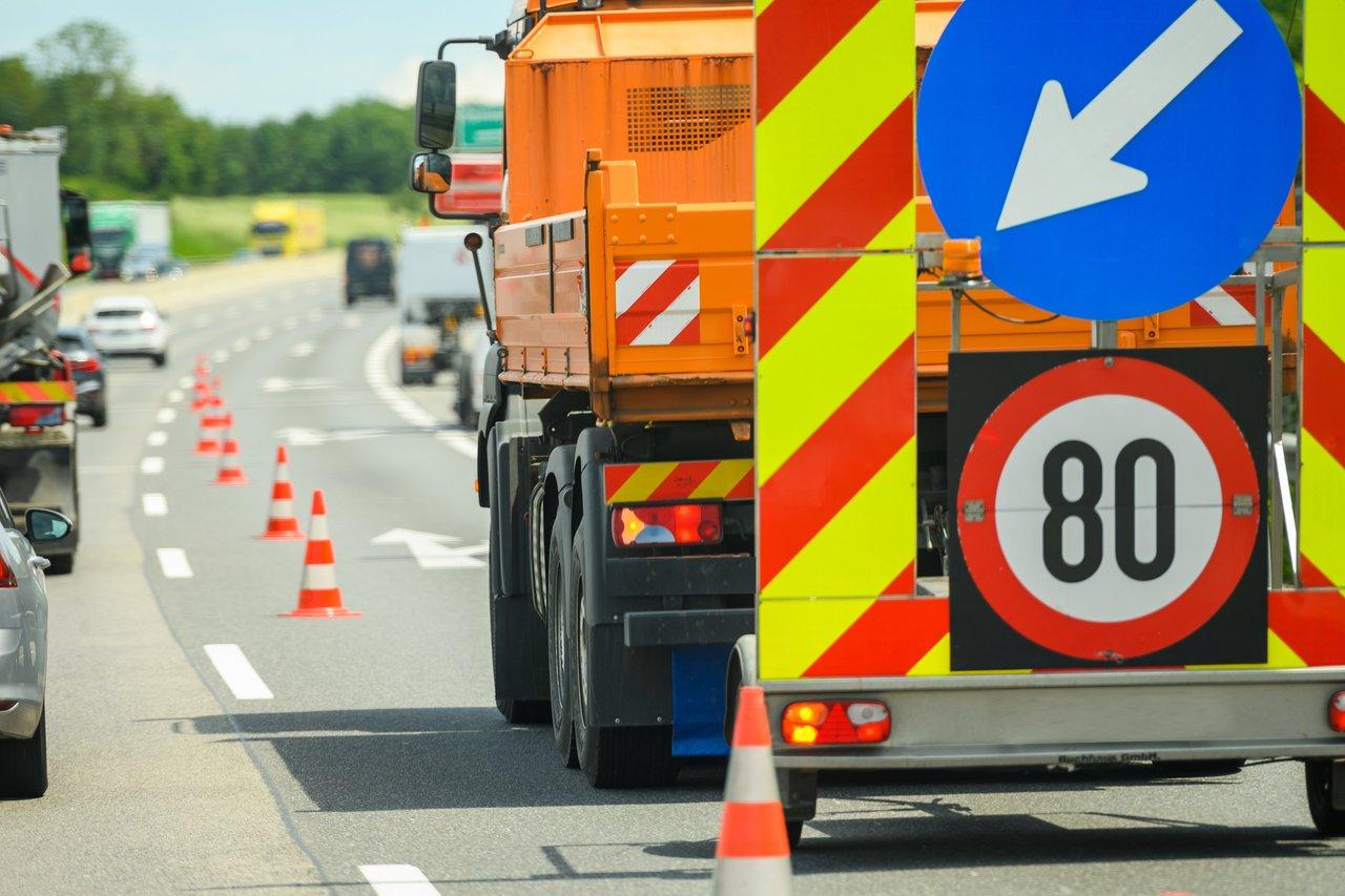 Zone de chantier autoroute A40 avec balisage orange, panneaux rétroréfléchissants et barrières de béton pour la sécurité.